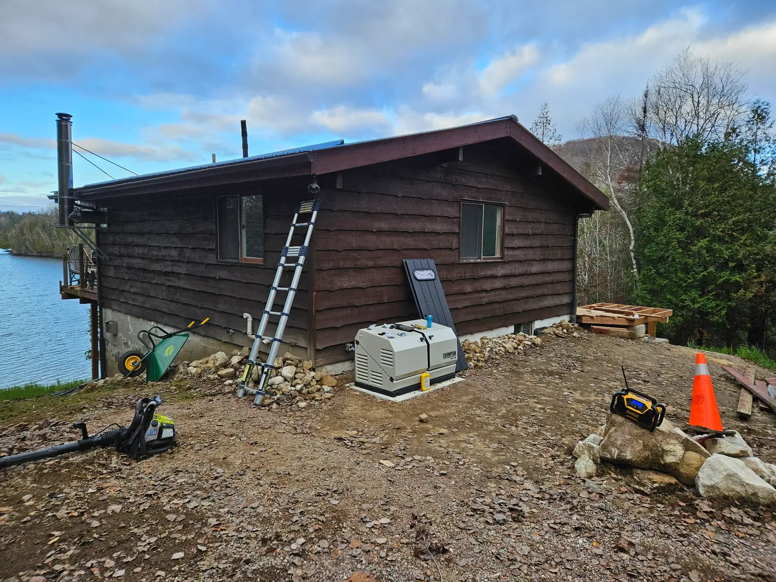 Standby generator on a concrete pad beside a rural cabin.