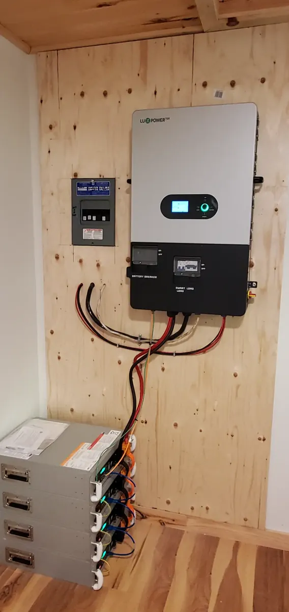 Wall-mounted inverter and battery modules in an indoor utility space.