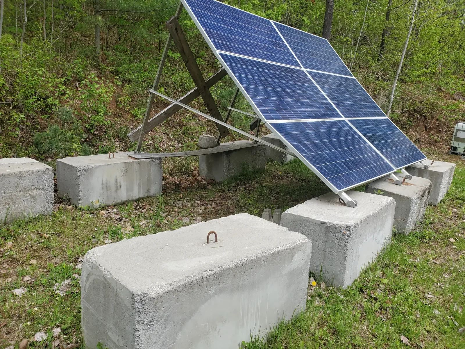 Pre-existing ground-mounted solar equipment with concrete ballast blocks, shown for technical review context and not installed by Property Developments.