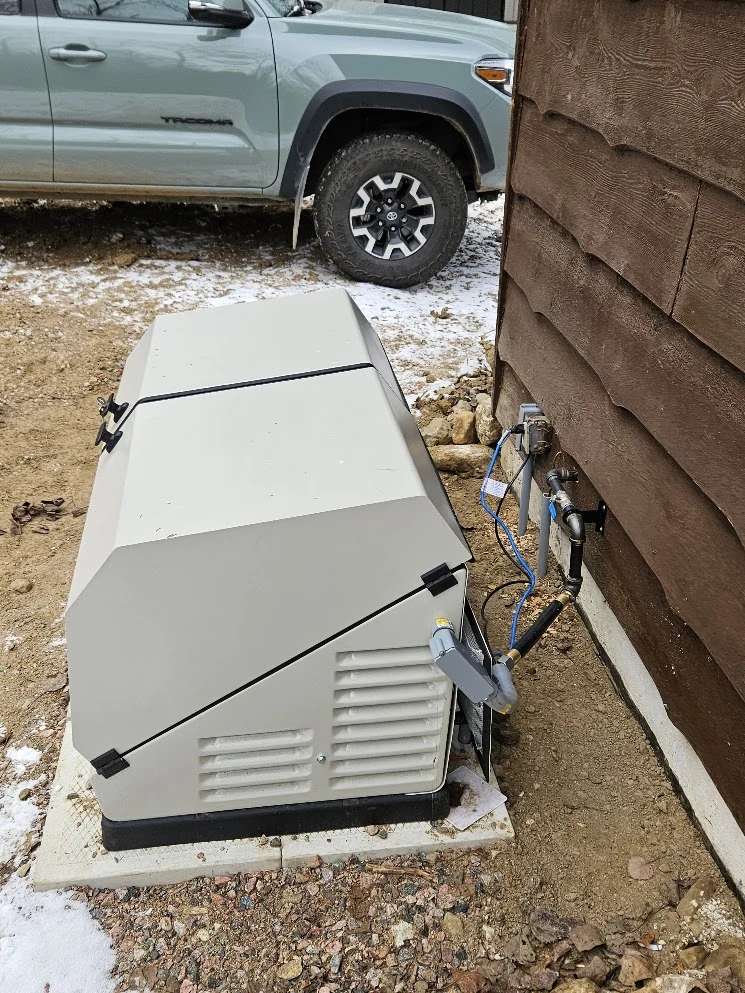 Permanently installed standby generator connected outside a rural property.